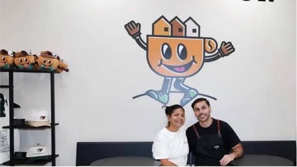 Sully and Chris Serna beneath their café’s original wall mural